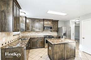 Tomball house for rent - A kitchen with a tile backsplash and wooden cabinets.
