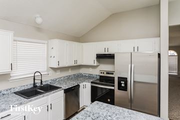 Mesquite house for rent - a kitchen with white cabinets and stainless steel appliances