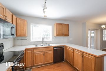 Thornton house for rent - A kitchen with wooden cabinets and a black dishwasher.