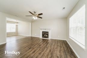 Charlotte house for rent - A spacious living room with a fireplace and wood flooring.