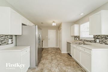 Charlotte house for rent - A kitchen with white cabinets and a tiled floor.