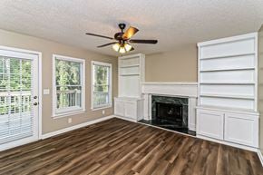 Powder Springs house for rent - an empty living room with a fireplace and a ceiling fan