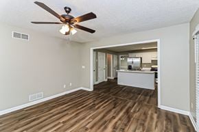 Powder Springs house for rent - an empty living room with a ceiling fan and a kitchen