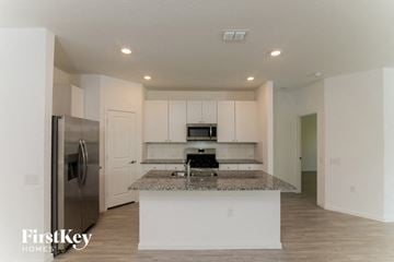 San Antonio house for rent - a kitchen with white cabinets and a granite counter top