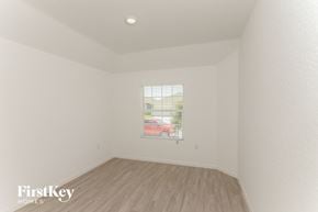 San Antonio house for rent - a bedroom with white walls and wood floors and a window