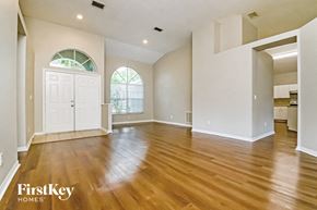 Valrico house for rent - an empty living room with a hardwood floor and a white door