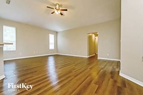 Valrico house for rent - an empty living room with wood flooring and a ceiling fan