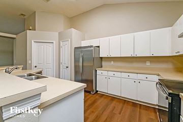 Valrico house for rent - an empty kitchen with white cabinets and a stainless steel refrigerator