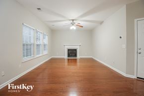 Summerville house for rent - A spacious room with a fireplace and wood flooring.