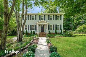 Greensboro house for rent - A house with a green lawn and trees in front of it.