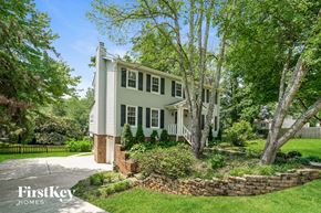 Greensboro house for rent - A house with a white picket fence and a brick pillar in front.