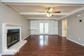 Greensboro house for rent - A spacious room with a fireplace and wood flooring.