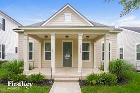 St Johns house for rent - the front of a white house with white columns and a green door