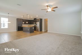 St Johns house for rent - an open living room and kitchen with a ceiling fan
