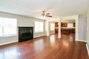 Dallas house for rent - an empty living room with a fireplace and a ceiling fan