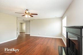 Dallas house for rent - the living room and dining room with wood flooring and a ceiling fan