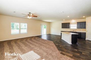 St Augustine house for rent - A spacious living room with a rug on the floor and a kitchen area in the background.