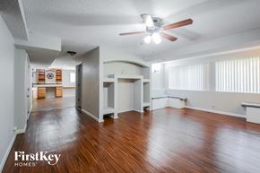 Lake St. Louis house for rent - A spacious room with wooden floors and a ceiling fan.