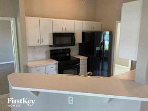 Cape Coral house for rent - a kitchen with a black stove and a refrigerator
