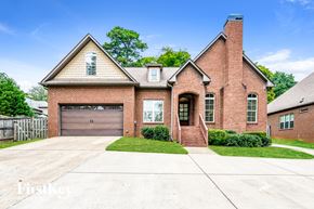 Hoover house for rent - A brick house with a garage door and a chimney.