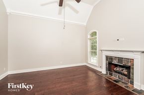 Hoover house for rent - A room with a fireplace and a fan on the ceiling.