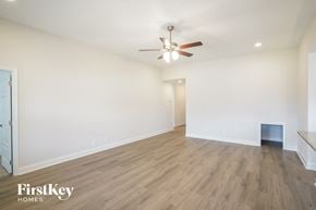 Clarksville house for rent - a living room with white walls and a ceiling fan