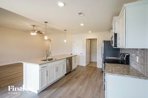 Clarksville house for rent - a kitchen with white cabinets and a counter top and a sink