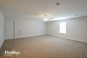 Clarksville house for rent - a bedroom with white walls and a ceiling fan