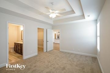 Clarksville house for rent - a spacious living room with carpet and a ceiling fan