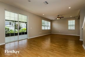 Riverview house for rent - A spacious room with wooden floors and a ceiling fan.