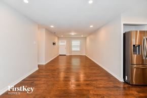 Garland house for rent - A long hallway with wood floors and a stainless steel refrigerator on the right.