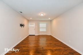 Garland house for rent - A room with wooden floors and white walls.