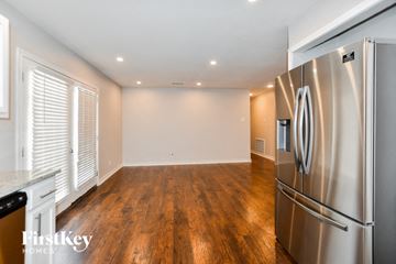 Garland house for rent - A stainless steel refrigerator sits in a kitchen with wooden floors and white walls.