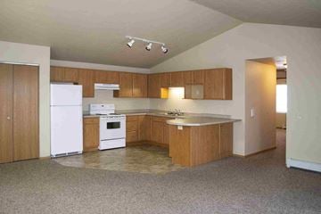 De Pere apartment for rent - an empty kitchen with white appliances and wooden cabinets