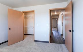 Sheboygan Falls apartment for rent - an empty bedroom with closet doors and a hallway to a closet