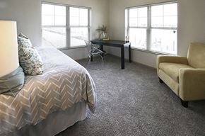 Oshkosh apartment for rent - a bedroom with a bed and a desk and two windows