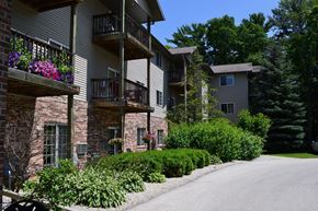 Sturgeon Bay apartment for rent - a street in front of an apartment building with flowers on the balconies