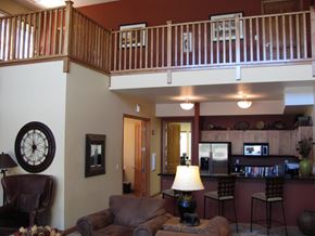 Reno apartment for rent - A living room with a couch, chair, and a clock on the wall.
