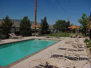 Reno apartment for rent - A pool surrounded by chairs and a fence.
