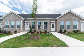 Martinsburg apartment for rent - the front of a brick house with a lawn and sidewalk