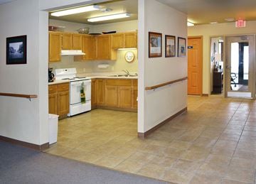 West Bend apartment for rent - A kitchen with wooden cabinets and a white stove top oven.