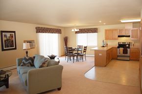 West Bend apartment for rent - A living room with a couch, chairs, and a dining table.