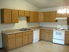 Marshfield apartment for rent - an empty kitchen with white appliances and wooden cabinets