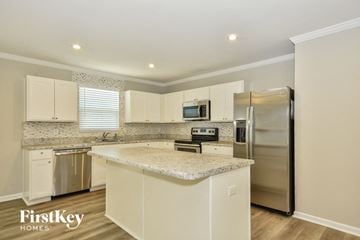 La Vergne house for rent - a kitchen with white cabinets and a granite counter top