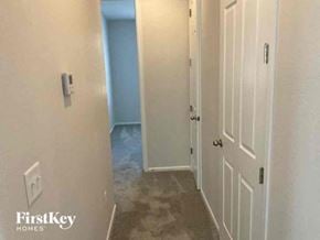 Commerce City house for rent - a hallway with a white door and a carpeted floor