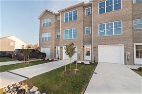Martinsburg apartment for rent - a sidewalk in front of a brick house with a white garage door