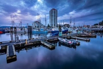 Nanaimo apartment for rent - A marina with boats docked and a tall building in the background.