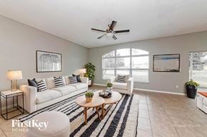 Parrish house for rent - A living room with a white couch, a wooden coffee table, and a ceiling fan.