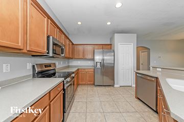 Parrish house for rent - A kitchen with wooden cabinets and a stainless steel refrigerator.