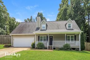 Dallas house for rent - A house with a white garage door and a black door is shown.